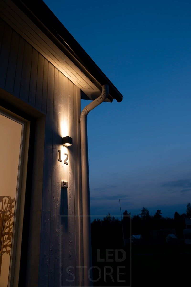 CUBIC OUT 2 wall light for outdoor use, illuminating the house number and the facade of the house.